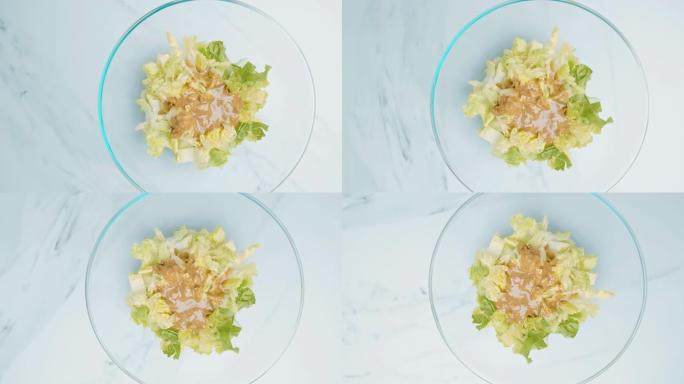 近距离观察4k新鲜制作的绿色健康凯撒沙拉。食材: 蛋黄，柠檬汁，an鱼，大蒜，橄榄油，面包，长叶莴苣