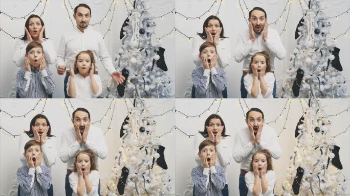 在新年背景下，年轻父母和他们的孩子的Slowmotion 4k视频，张开嘴，双手放在脸颊上，用恐怖的