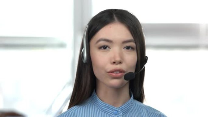 白人年轻的亚洲女孩用耳机说话。