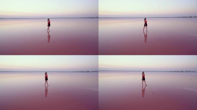 在乌克兰的粉红色盐湖上行走的女人