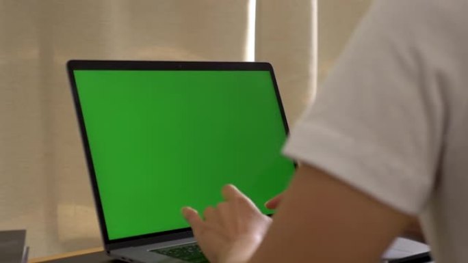 一名印度女商人在办公桌上的pc上的办公室内部工作，看着绿屏。办公室人员使用带笔记本电脑绿屏的笔记本电