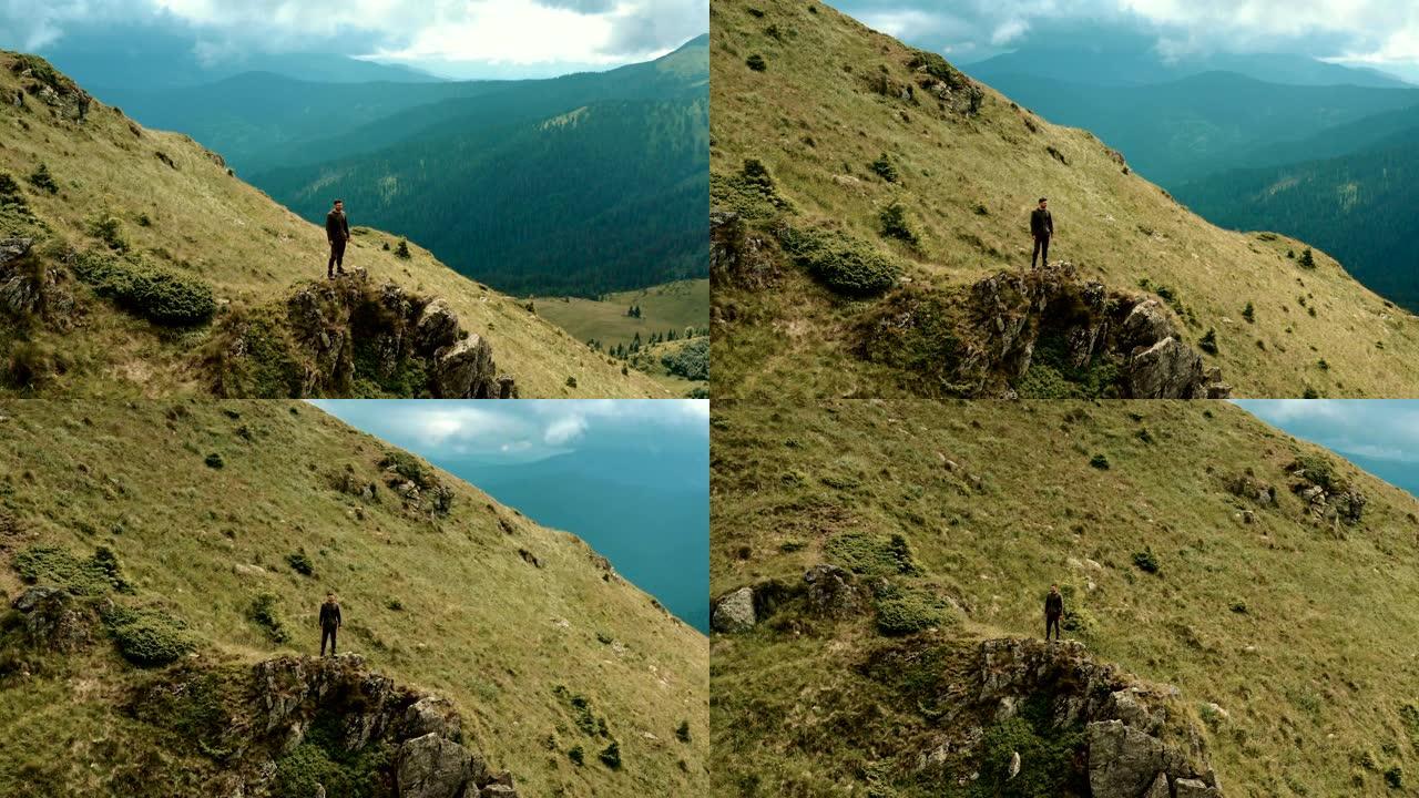 这个人站在山崖上成功登顶勇攀高峰获得成功