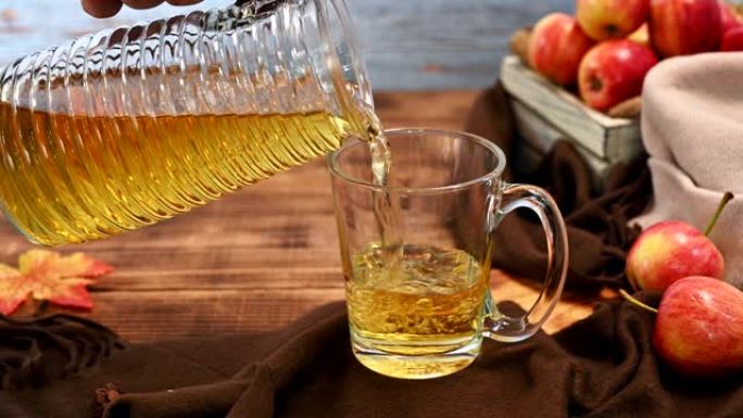 木箱中的有机成熟红苹果新鲜果汁。秋季收获聚宝盆。饮料和水果与木桌背景。