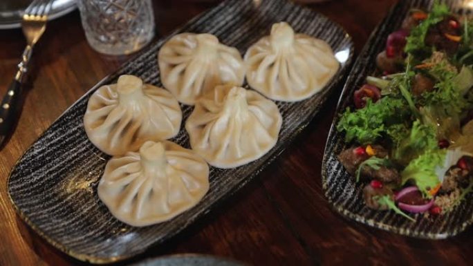 传统的格鲁吉亚饺子，Khinkali，桌上有沙拉。准备吃格鲁吉亚菜