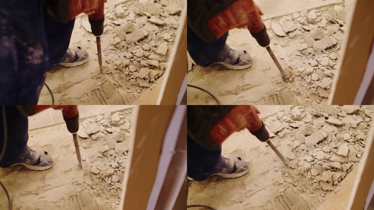 手提凿岩机员工打破地板上的混凝土覆盖物