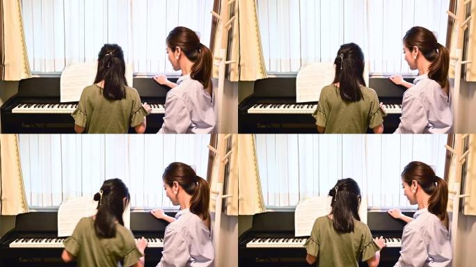母女俩弹钢琴。