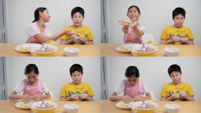 快乐亚洲儿童在家一起包饺子，生活理念。