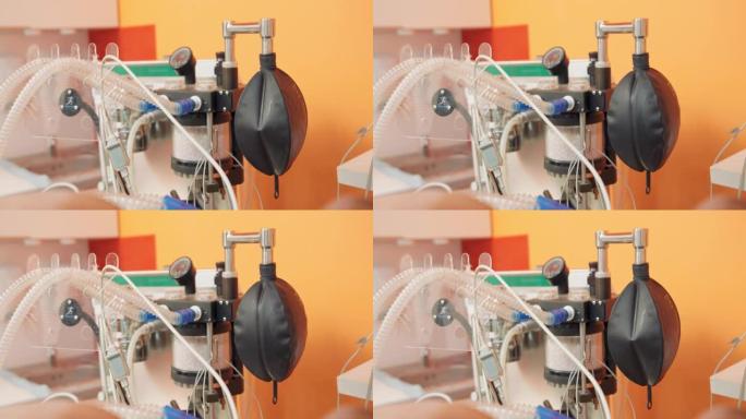 在动物手术期间关闭用于人工肺通气的设备的一部分，并在手术室中使用手术台和转向计算机。模糊的橙色墙壁和
