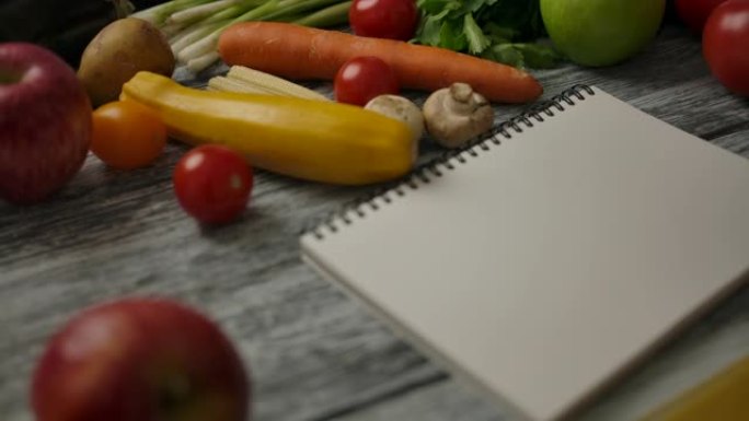 木制桌子上靠近烹饪原料的空白笔记本