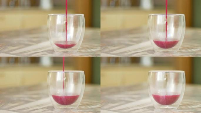 粉红色抹茶拿铁，由热鲜牛奶和火龙果粉制成，放在桌子上的双玻璃杯中