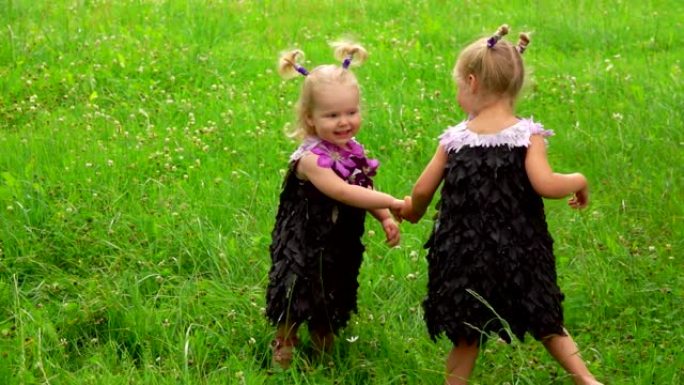 两个女孩穿着树叶和花朵制成的连衣裙