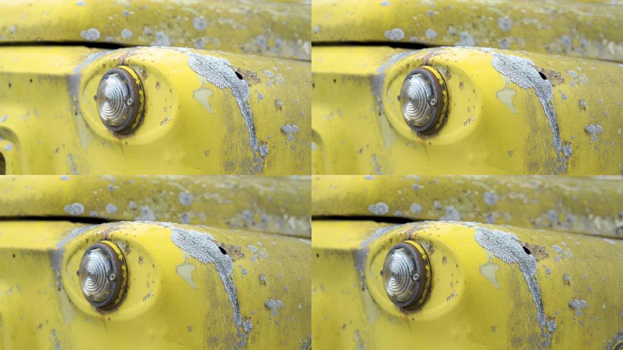 老式汽车的黄色生锈油漆的近距离观察