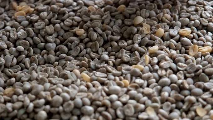 一位老妇人的手通过阿拉比卡咖啡豆进行分类，对东南亚咖啡种植厂进行质量控制和选择。