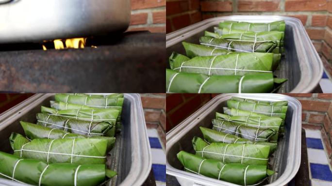 在煤气炉燃烧器顶部的蒸汽炊具中手持烹饪hallacas的照片。委内瑞拉传统圣诞食品。