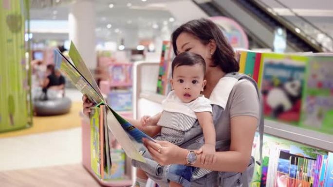 一个亚洲男婴，母亲抱着书店。