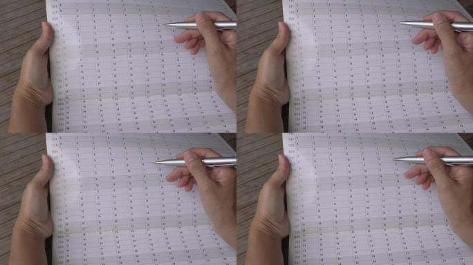 女人用手指，用笔穿过年度日历计划器。