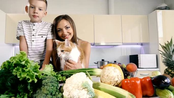 厨房和蔬菜。妈妈带着一个孩子和一只猫在厨房里准备健康的食物。