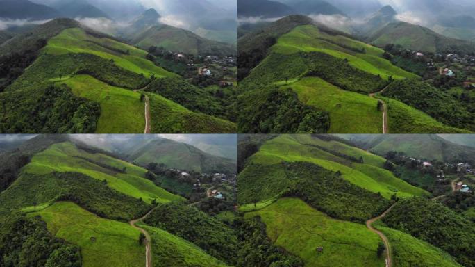 4k空中无人机拍摄于巨大的绿色富山，大自然母亲的宝藏，高地村庄，雾蒙蒙的阳光透过云，全景景观，地球，