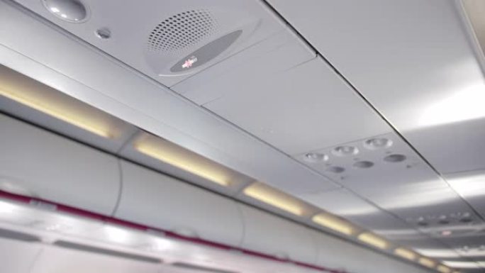 机舱天花板，带负载扬声器，禁止吸烟标志。