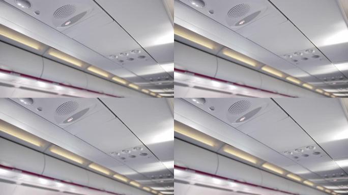 机舱天花板，带负载扬声器，禁止吸烟标志。