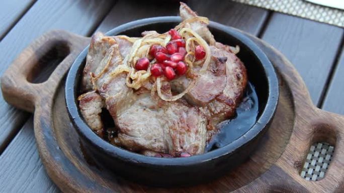 美味的格鲁吉亚美食。在粘土锅中煎肉，配洋葱和石榴籽。