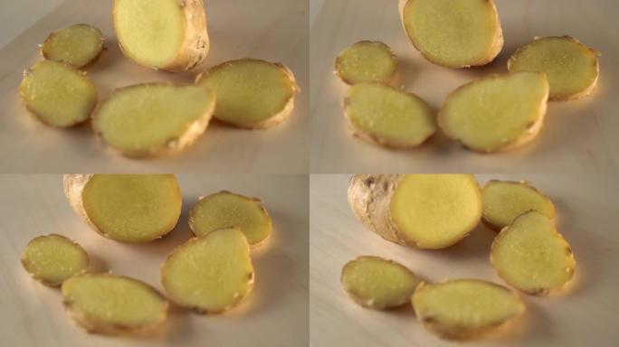 多汁成熟的姜根切片在木质表面上旋转。