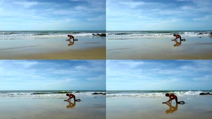 女孩在沙滩上练习瑜伽，以对抗沙滩上的波浪