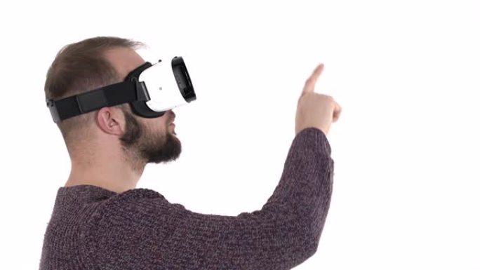 使用虚拟现实眼镜的年轻人感到惊讶。震惊的白人男子穿着VR google用食指指着某物