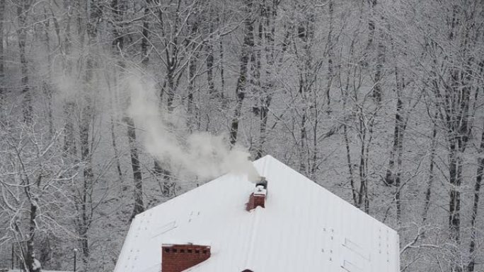 雪背景上的烟囱冒烟。