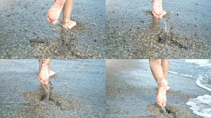 特写嬉戏的孩子脚在海滩潮湿的沙滩上奔跑，感觉积极的情绪慢动作