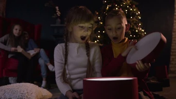 肖像在圣诞节期间拍摄了快乐的孩子打开礼物，并看到了特别的惊喜