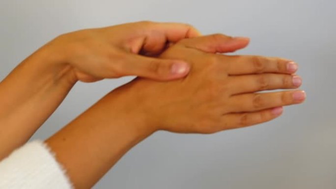 手腕疼痛。女性的手触摸手腕并试图拉伸关节。肌腱炎，滑膜炎，骨关节炎，扭伤，类风湿性关节炎概念。特写