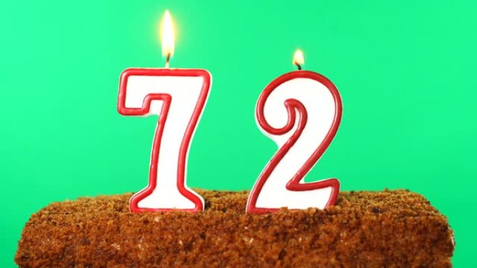 带有72号点燃蜡烛的蛋糕。色度键。绿屏。隔离