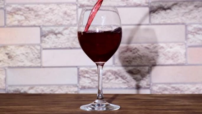 红酒从瓶中倒入白色背景的高脚杯中。将玫瑰酒倒入玻璃杯中。酒杯