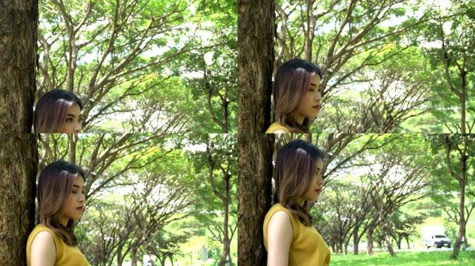 亚洲女人悲伤女孩失恋不开心背靠在树上