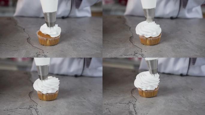 糕点袋的特写镜头将奶油放在蛋糕上