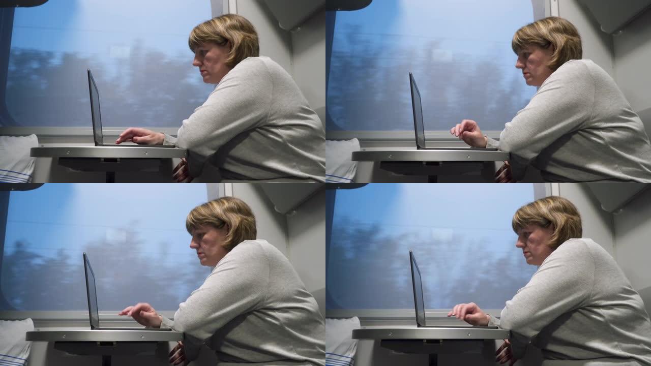 一个女人正在坐火车，她坐在窗边，用笔记本电脑工作