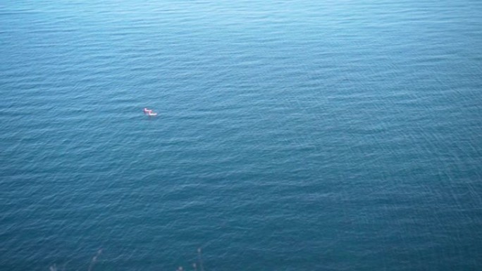 两名冲浪者漂浮在碧绿波海的浮板上。空中圆形视图。