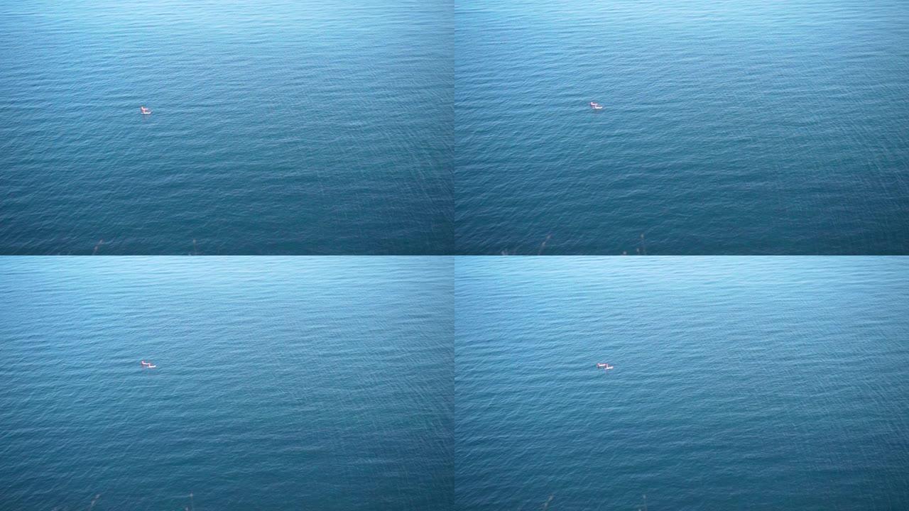两名冲浪者漂浮在碧绿波海的浮板上。空中圆形视图。