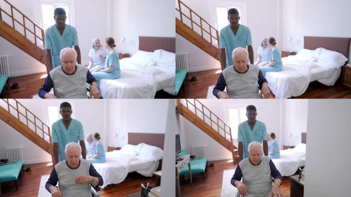 男护士在疗养院帮助老人坐轮椅