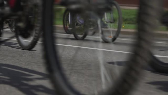 城市中的大众自行车骑行。自行车马拉松。自行车手的比赛项目。市民在大街上骑自行车。一列运动员。车轮的低