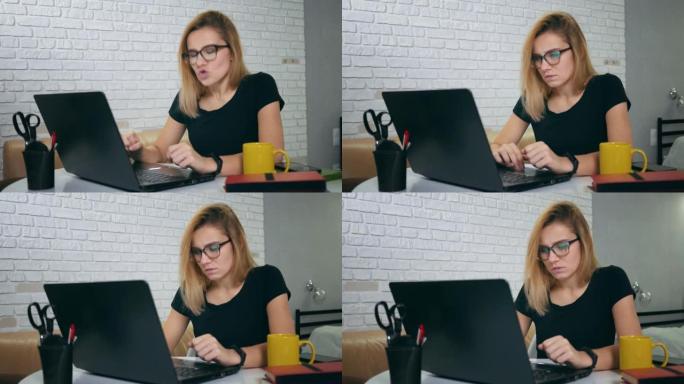 愤怒的女人在家在笔记本电脑上打字。担心的年轻女子在家工作场所在线笔记本电脑。紧张的女孩在家里看着笔记