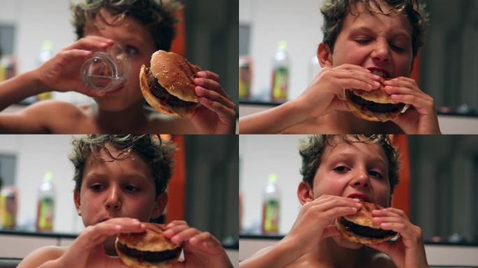 小男孩吃饭。孩子喝水和吃汉堡