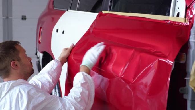在维修过程中，工人正在用胶带覆盖汽车门