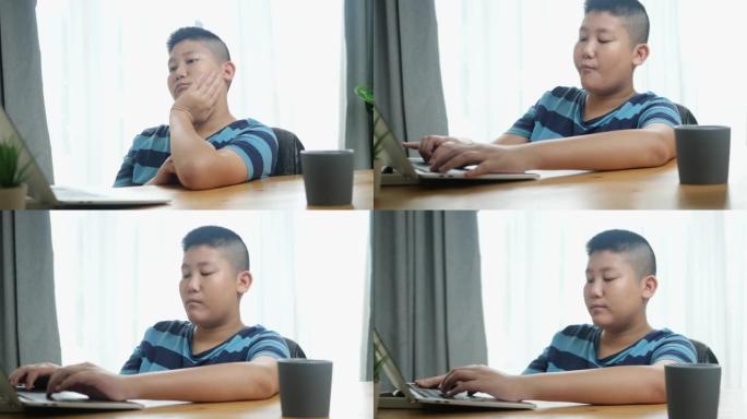 亚洲男孩在新型冠状病毒肺炎期间用笔记本电脑做作业，新的正常概念。