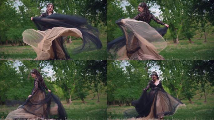 哥特式女王在黑暗的森林中穿着黑色复古飞行连衣裙。织物飘动