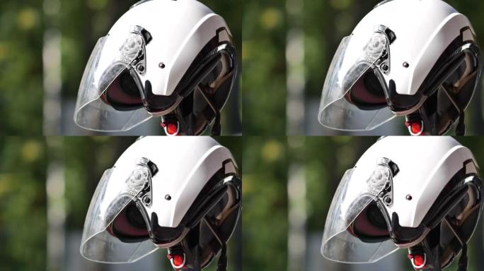 路边停放的摩托车上的白色摩托车头盔。自行车驾驶员保护器