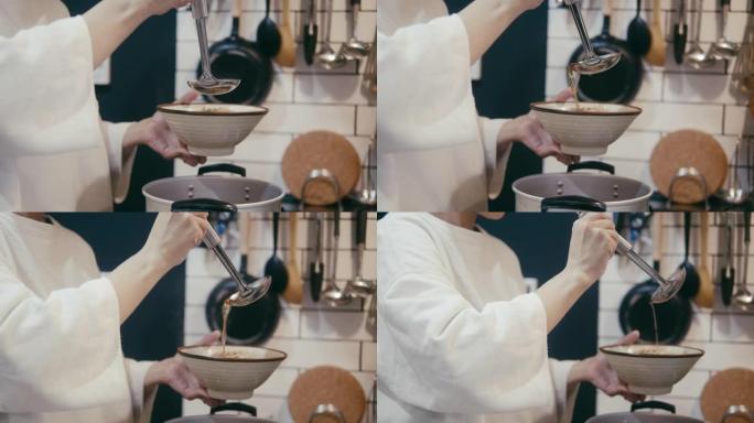日本妇女将肉汤倒在荞麦荞麦面上