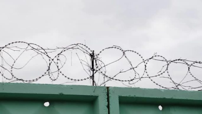 监狱里铁丝网的特写镜头。带刺铁丝网的监狱。带铁丝网的绿色围栏