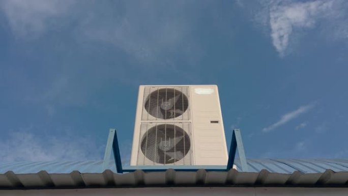 蓝天背景屋顶上的空调压缩机。手持镜头
